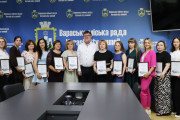 Колективне фото працівників бухгалтерської сфери Вараської громади спільно з міським головою м.Вараш Олександром Мензулом. Позаду людей синій банер з логотипом "Вараська міська рада Varash city council"
