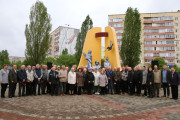 25 квітня 2025 року у Вараші відбувся мітинг-реквієм, присвячений 39-ій річниці Чорнобильської катастрофи. На фотографії зображено учасників заходу біля пам'ятника "Жертвам Чорнобильської катастрофи". Серед присутніх - ліквідатори наслідків аварії, представники міської влади Вараша та громадськість. Люди зібралися, щоб вшанувати пам'ять загиблих та віддати шану героїзму ліквідаторів. На задньому плані видніються житлові будинки та дерева, що створює атмосферу міського меморіального заходу.